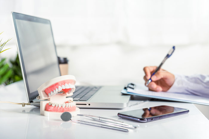 false-jaw-and-dental-elements-in-front-of-a-dentist-working-on-a-computer