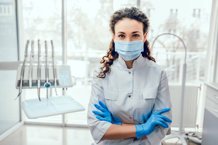 female-dentist-with-mask-in-front-of-dental-equipment